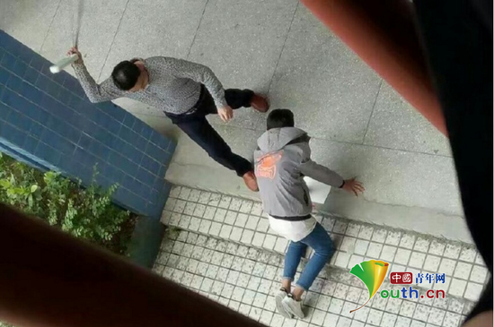 張姓老師手拿帶插線板的電線毆打跪在地上的學生。