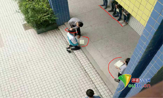 圖片顯示，張姓老師揪住跪在地上的學生的頭髮，學生面前還有一排學生靠牆站著，側面也有學生站著。